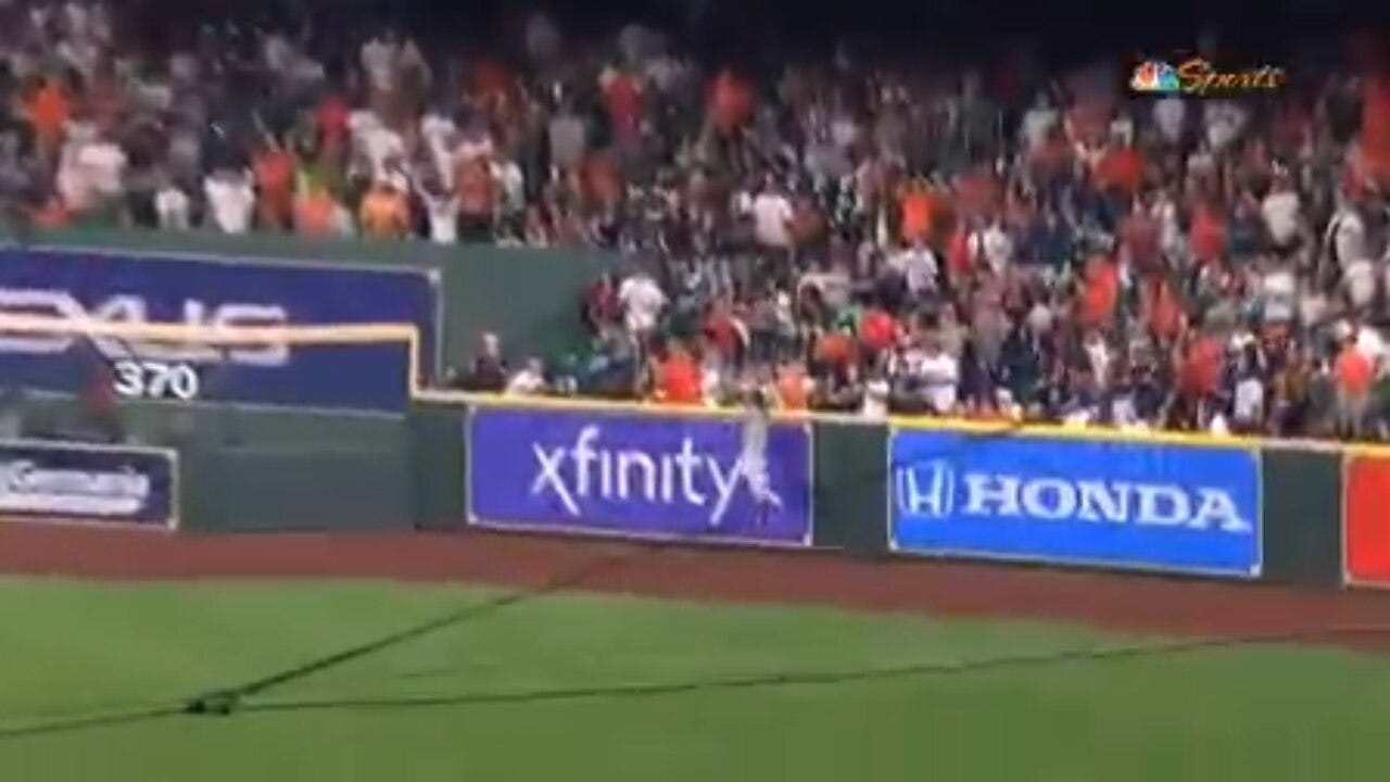 Athletics' Ramón Laureano makes a leaping grab at the wall to rob Astros' Jeremy Peña of extra bases